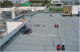 Lezuhanás ellen biztosító rendszerek lapostetőn végzett munkákhoz