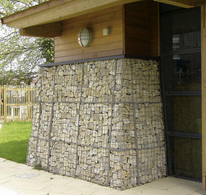 Látványos homlokzatburkolat kövekkel töltött drótkosarakból